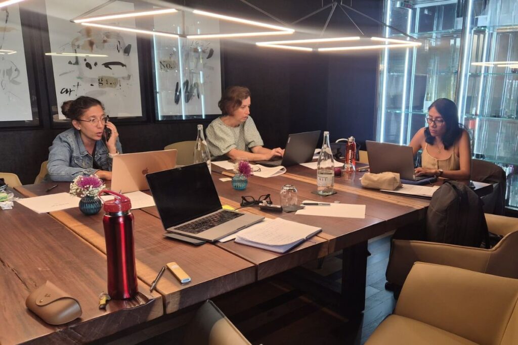 Corporate team working together around a boardroom table setting objectives to improve corporate event ROI