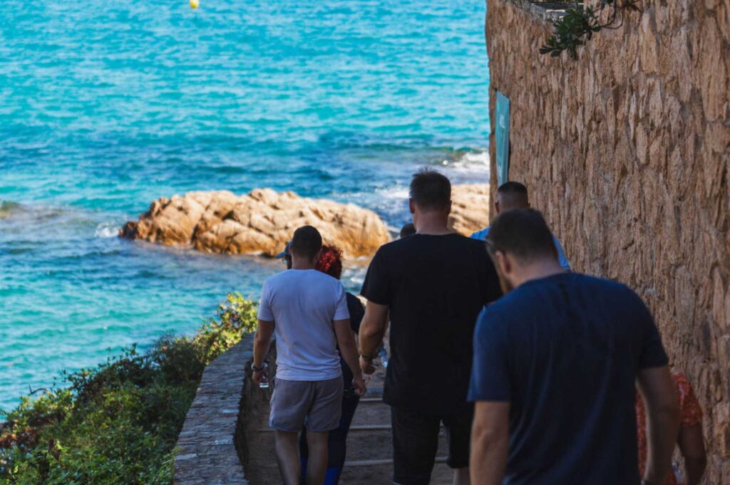 Corporate conference wellness activities: group doing morning seaside hiking near Barcelona