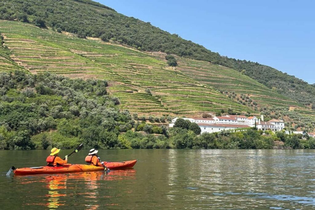 Tandem kayaks on the Douro River beside terraced vineyards