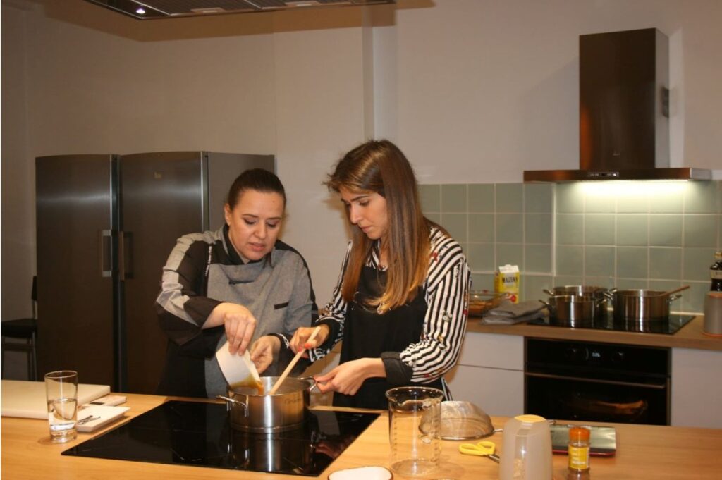 Colleagues preparing a Francesinha sandwich in a cooking class