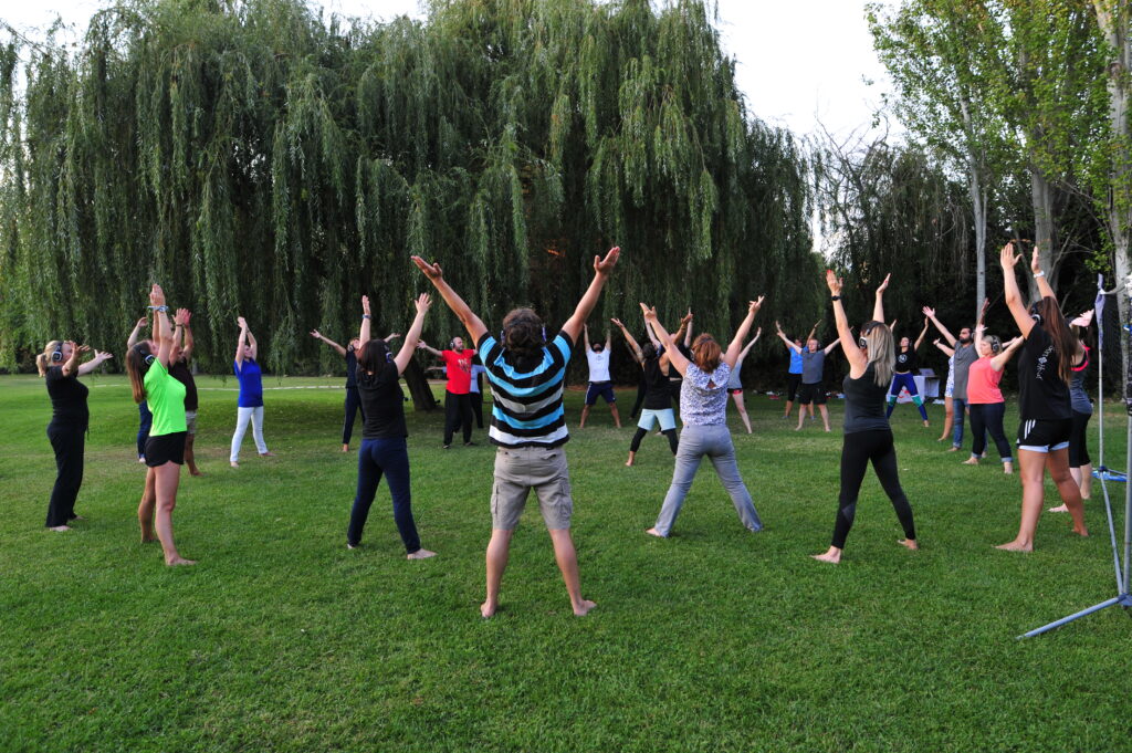 Corporate event wellness activities: group doing tai-chi at the garden of a hotel in Portugal